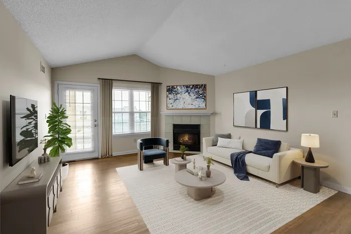 Inviting living room with modern decor, featuring a cozy fireplace, elegant sofa, and stylish artwork, natural light streaming through large windows.