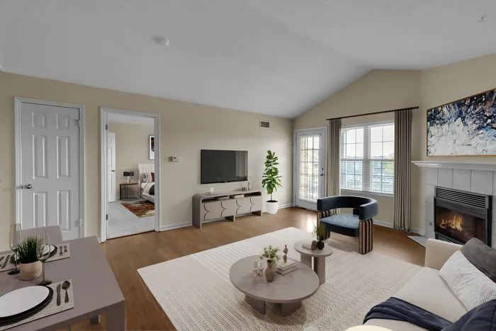 Inviting living room with modern fireplace, sleek furniture, and abundant natural light, leading to a stylish bedroom.