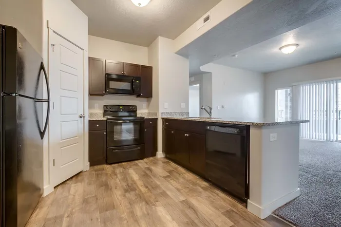 Wider angle of kitchen showing walk-in pantry and fridge/freezer combination, and ample counter space.