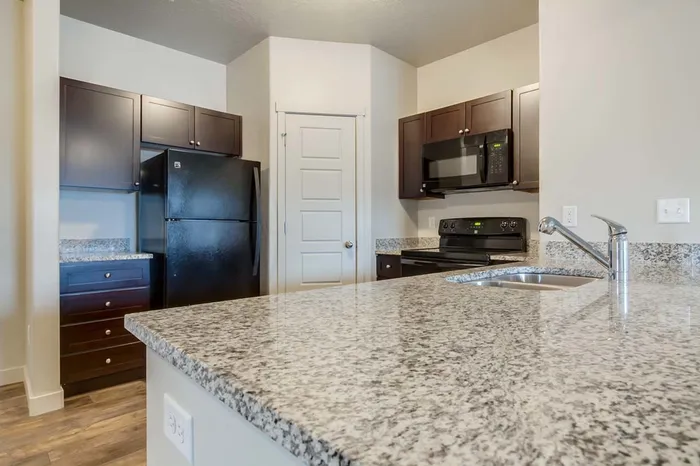 View of granite counter top peninsula and corner pantry