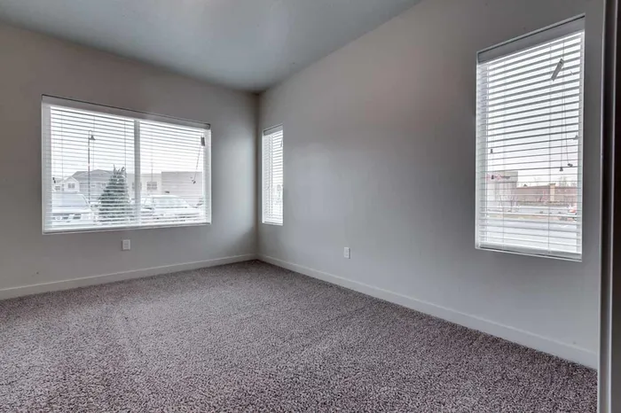 Master bedroom with large window and two small side windows.