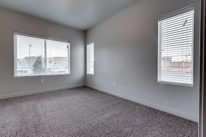 Master bedroom with large window and two small side windows.