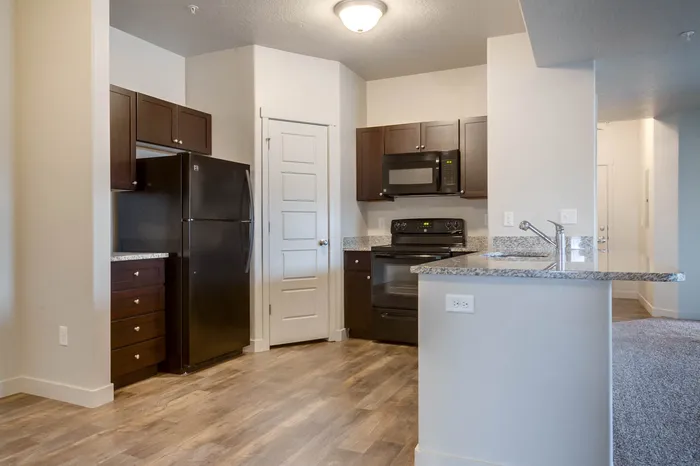 Another view of the kitchen showing appliance outlet in the counter peninsula with sink.