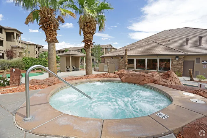 3.5 feet deep circular hot tub located above pool and waterfall