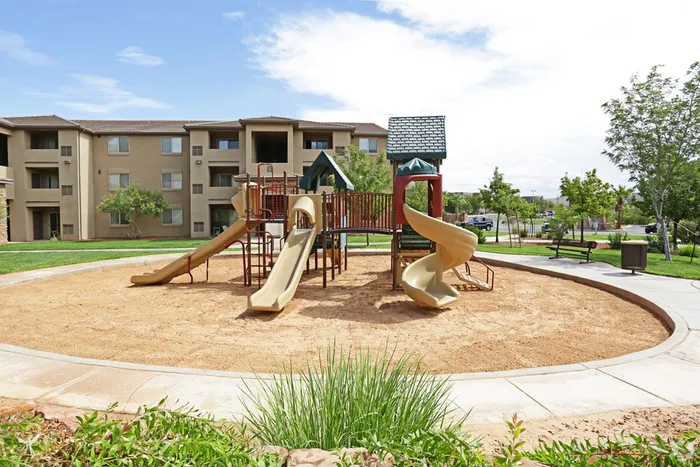 Playground area in sand pit with 4 slides and various climbing structures