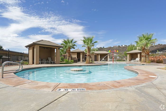 Large 3 feet 6 inch deep pool with splash pad area in front of 4 pool cabanas
