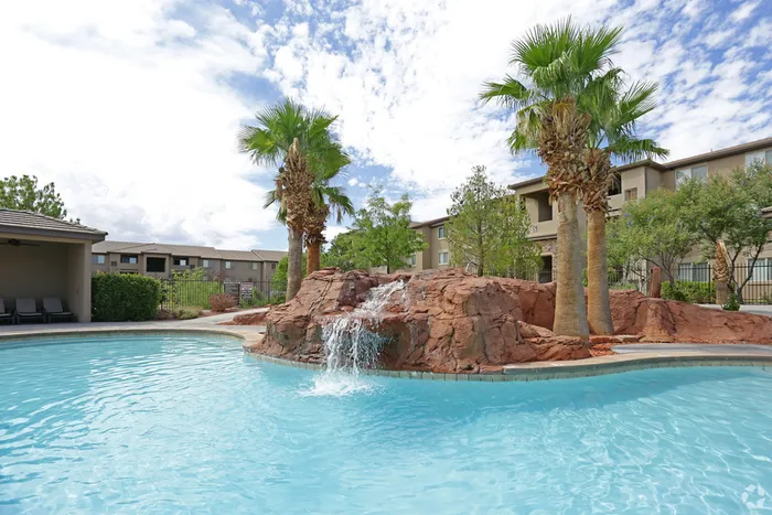 Swimming pool with waterfall feature flowing from hot tub above to pool beneath