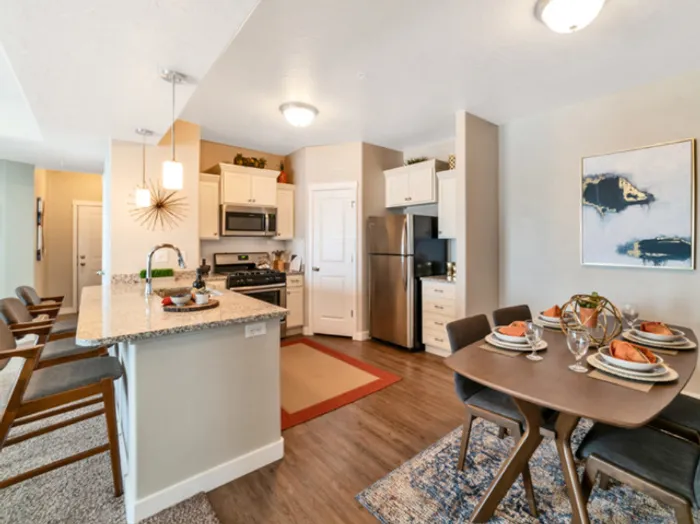 Kitchen and dining room with 4 person rectangular table and breakfast bar