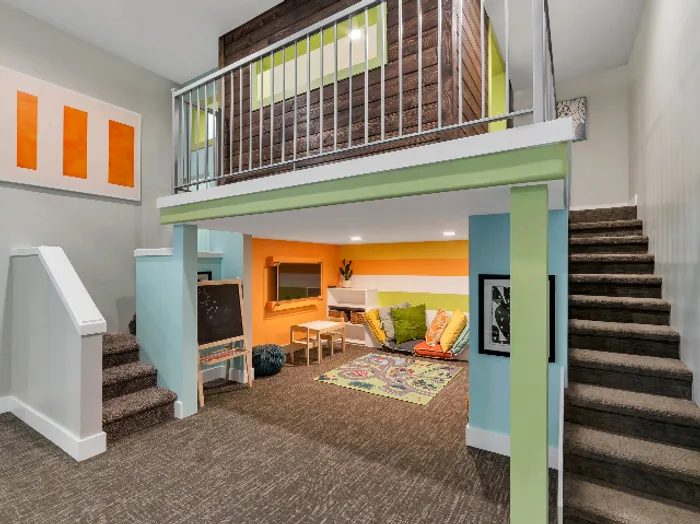 2 level play room shaped like a house with stairs, slide, play kitchen, television, and toy shelf
