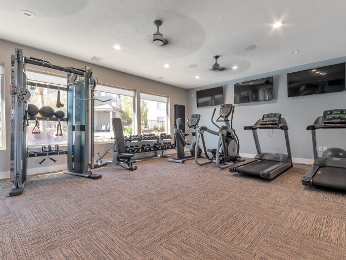 Fitness Center view of pulley system, seat, barbells, yoga mat, stationary bicycle, elliptical, and two treadmills
