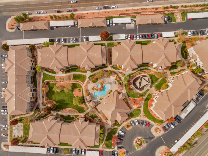 Aerial View of The Falls at Mesa Point showing detached garage buildings, courtyard, clubhouse and pool, playground, and buildings