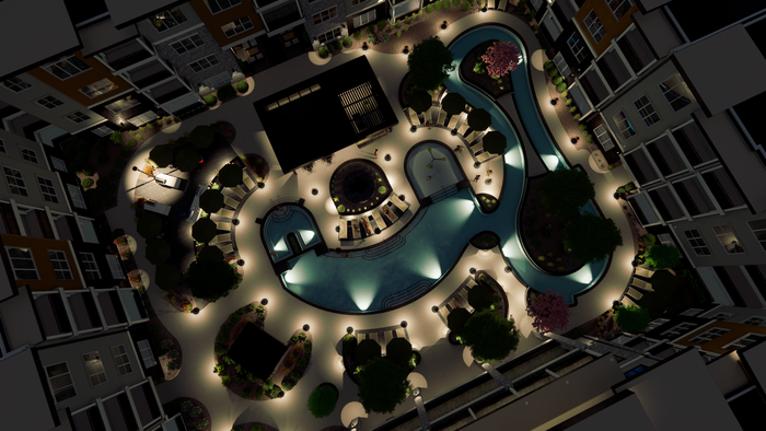 Night aerial view of interior pool courthouse area highlighting the swimming pool, lazy river, pool pavilions and lounging areas.