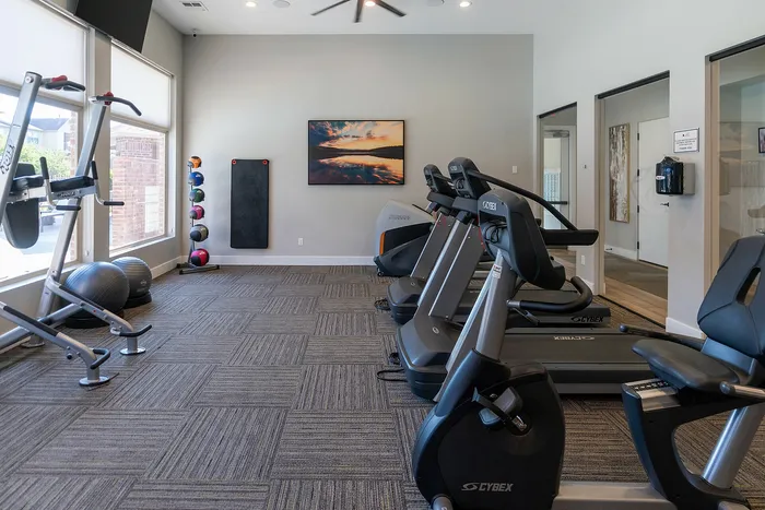 Bright and inviting fitness center with modern treadmills, stationary bike, and yoga equipment, perfect for an energizing workout.