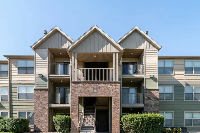 Charming apartment building with a classic brick facade, featuring spacious balconies and well-maintained landscaping.