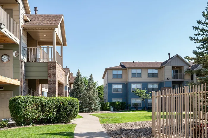 Charming residential community with modern townhouses surrounded by lush greenery and a well-maintained path, ideal for tranquil living.