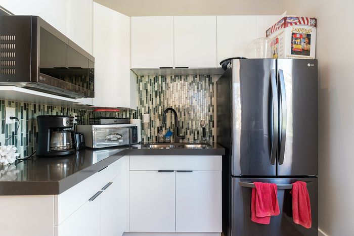 Modern kitchen with sleek stainless steel appliances, stylish mosaic backsplash, and elegant white cabinetry.