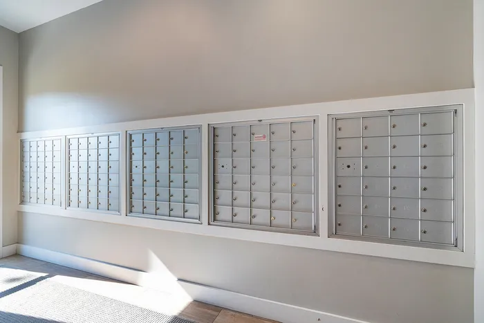 Contemporary apartment mailroom with sleek silver mailboxes, offering secure and organized mail storage.