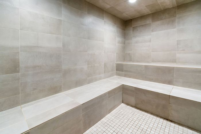 Modern steam room with sleek tiled walls and seating, offering a luxurious relaxation space.