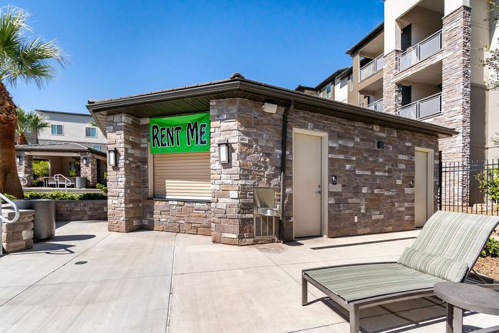 Charming stone-built poolside area with sunny lounge chairs and lush surroundings inviting you to rent today.