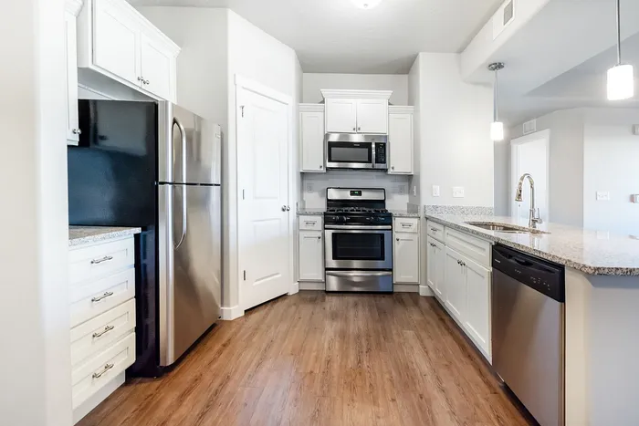 Contemporary kitchen with sleek stainless steel appliances, elegant granite countertops, and stylish white cabinetry.