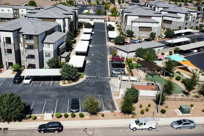Modern apartment complex with lush greenery, ample parking, and recreational spaces, offering a vibrant community living experience.