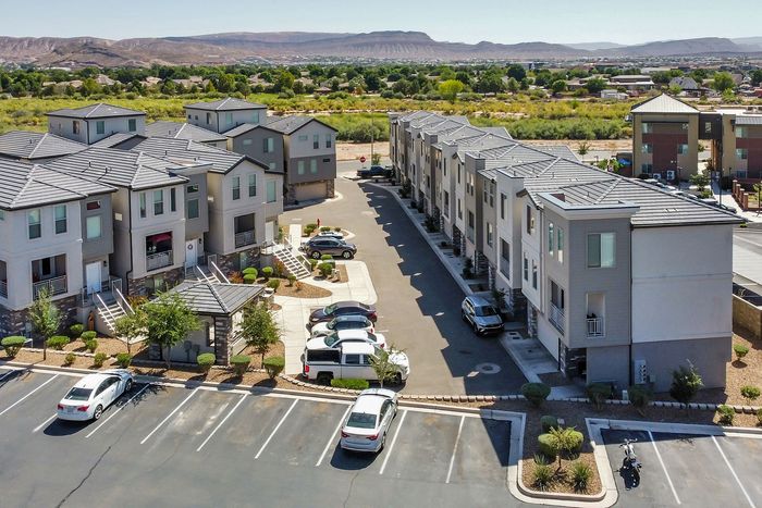 Charming modern townhouses with scenic mountain views in a serene neighborhood setting, showcasing ample parking and lush greenery.