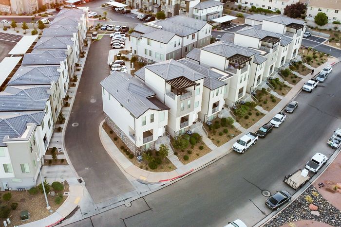 Modern townhouse development with sleek architecture, landscaped greenery, and ample parking options in a peaceful suburban setting.