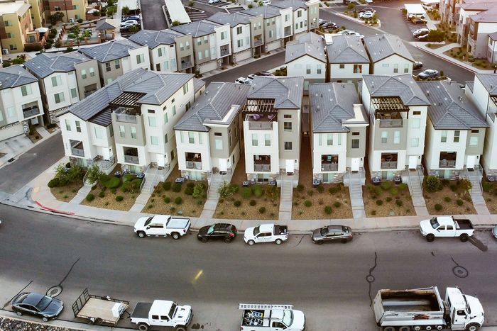 Aerial view of a modern row of duplex townhomes with neatly landscaped front yards in a charming neighborhood setting.