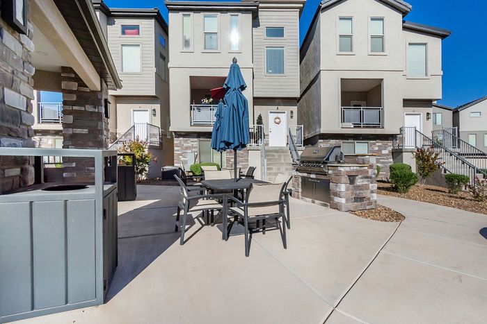 Charming modern townhouse with inviting patio and barbecue area, perfect for outdoor gatherings.