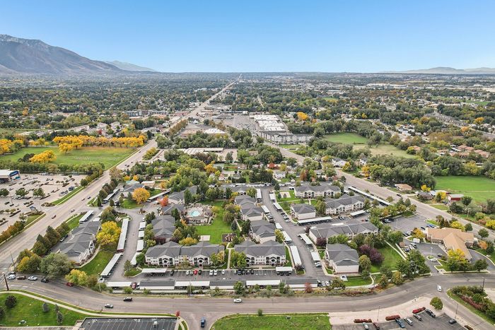 Breathtaking aerial view of a vibrant residential community surrounded by lush greenery and mountain vistas, perfect for tranquil living.