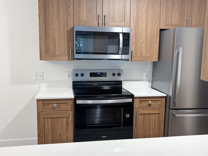 Modern stainless steel appliances paired with warm cabinetry create a kitchen you'll love coming home to.