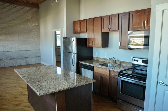 Modern kitchen with stainless steel appliances, granite countertops, and rich wooden cabinetry, offering a perfect blend of style and functionality.