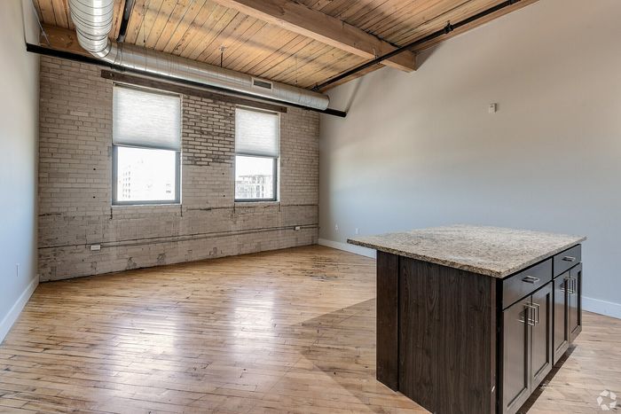 Chic industrial loft with exposed brick walls, high timber ceilings, and a stylish kitchen island.