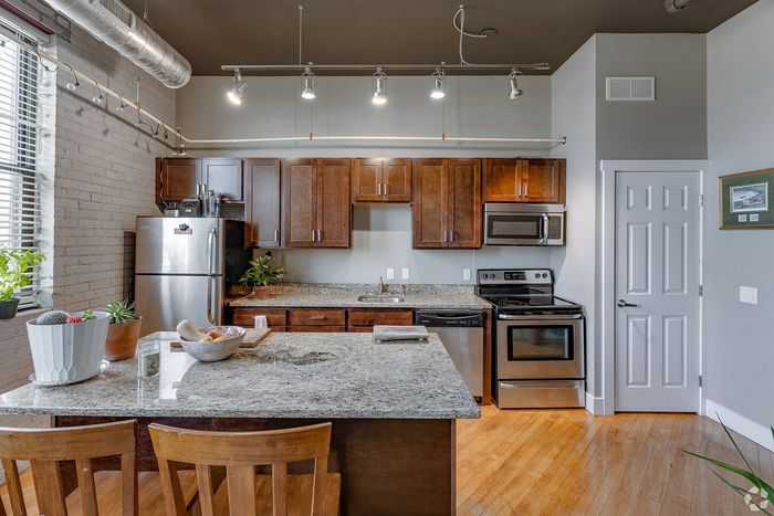 Contemporary kitchen with sleek granite countertops, elegant stainless steel appliances, and stylish wooden cabinetry, perfect for gourmet cooking.