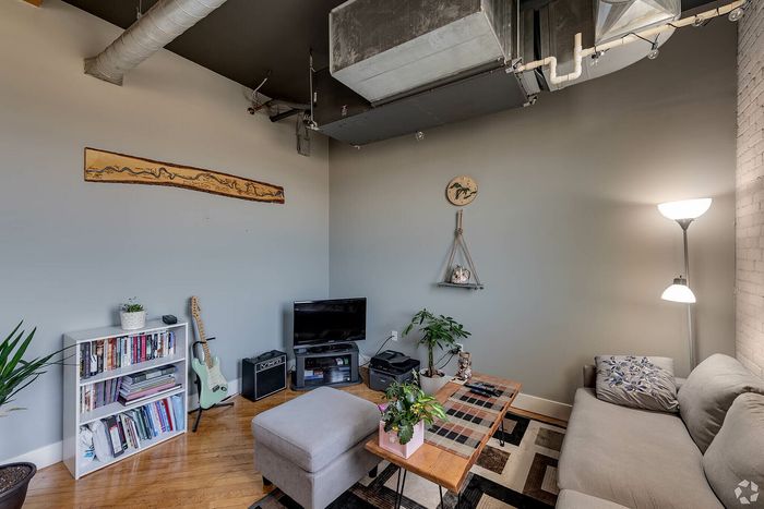 Inviting living room with modern decor, featuring a cozy sofa, stylish coffee table, and vibrant indoor plants for a relaxed atmosphere.