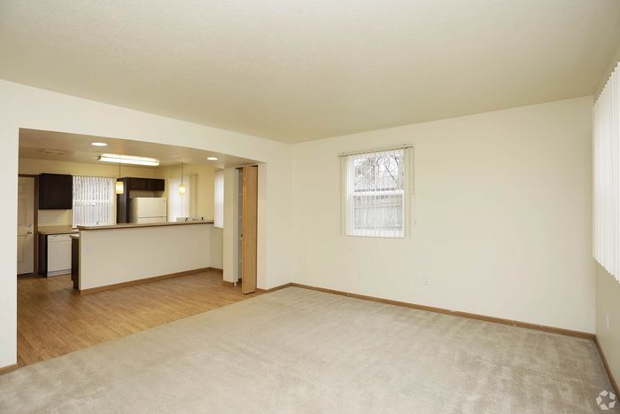 Bright and spacious open-plan living room with modern kitchen, featuring elegant flooring and ample natural light.