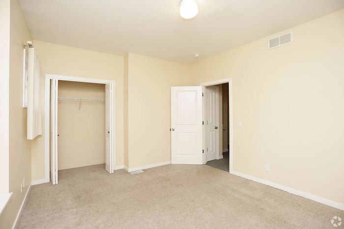 Bright and spacious bedroom with plush carpet, ample closet space, and clean neutral walls.