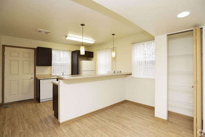 Bright and modern kitchen with sleek countertops, warm wood flooring, and ample storage space.
