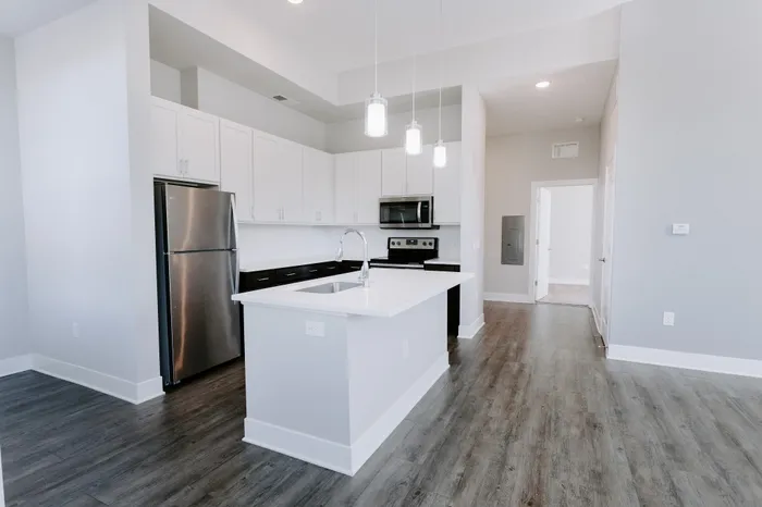 Bright contemporary kitchen with stainless steel appliances, white cabinetry, and an elegant island.
