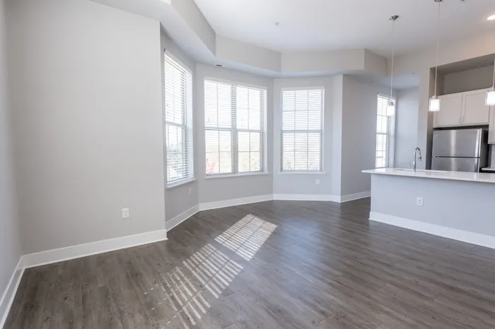 Spacious open-concept living area with large windows and modern kitchen.