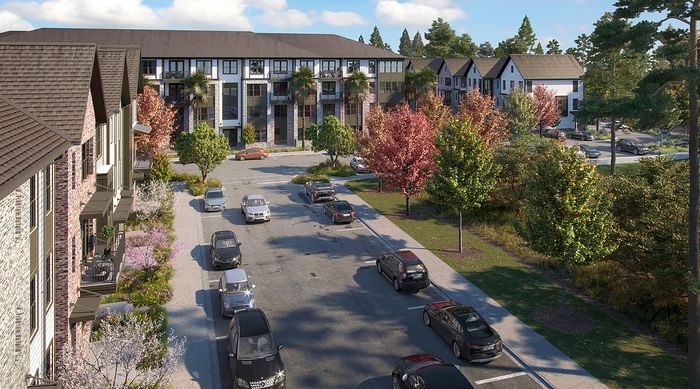 Charming residential street lined with modern townhouses, vibrant autumn trees, and parked cars under a clear blue sky.