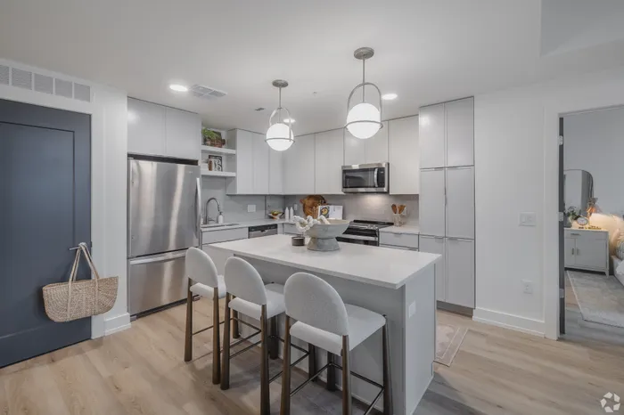 Modern kitchen with sleek cabinetry, stainless steel appliances, and a spacious island with chic pendant lighting.