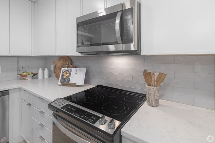 Modern kitchen with sleek stainless steel appliances, pristine white cabinetry, and elegant countertops.