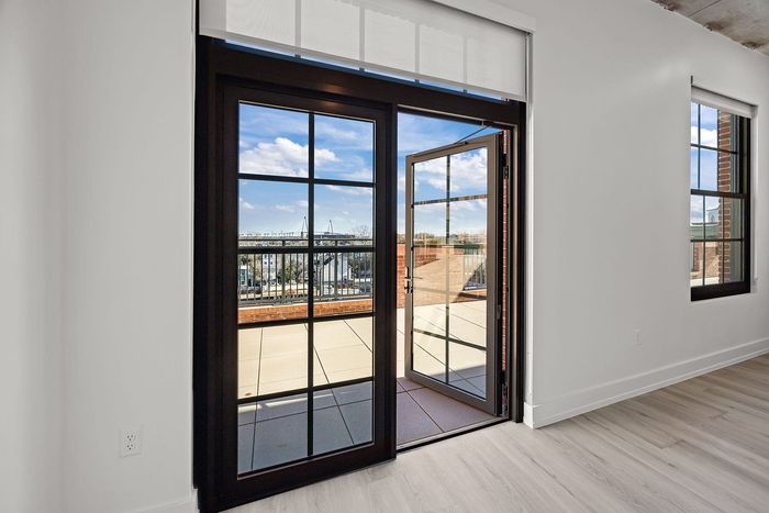 Bright apartment interior featuring large glass doors opening to a sunny terrace with stunning views.