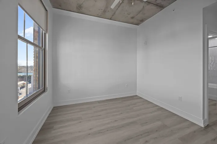 Chic and modern room featuring floor-to-ceiling windows, sleek hardwood floors, and a calming color palette, perfect for urban living.