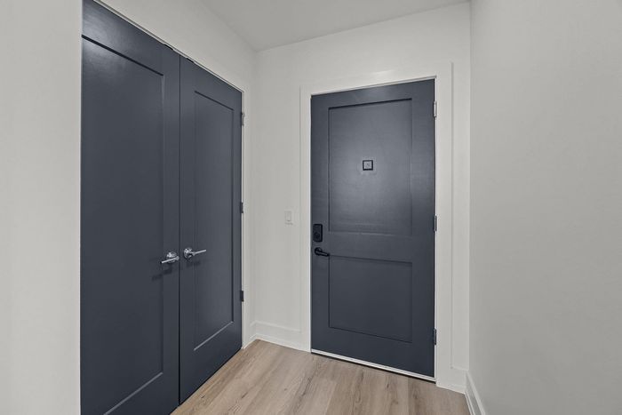 Modern entrance with sleek dark doors and elegant wooden flooring, providing a sophisticated welcome to your dream home.