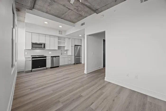 Modern, open-concept kitchen with sleek cabinetry, stainless steel appliances, and elegant wood flooring. Ideal for urban living.