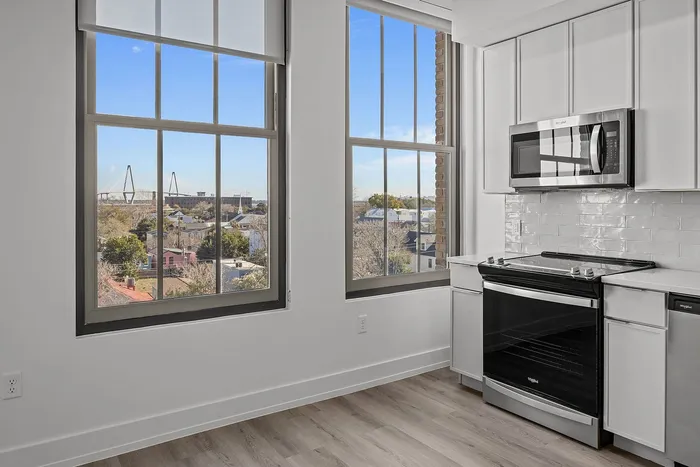 Bright kitchen with modern appliances and large windows offering stunning city and bridge views.