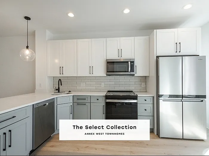 Elegant kitchen in The Select Collection at Annex West Townhomes showcasing modern appliances, sleek cabinetry, and a stylish open design.