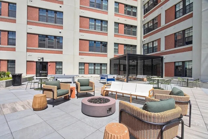 Modern outdoor patio with stylish seating, fire pit, and shaded lounge area, perfect for relaxation and gatherings.